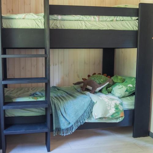 a bunk bed with a teddy bear on top of it at Pussala Latgalē 