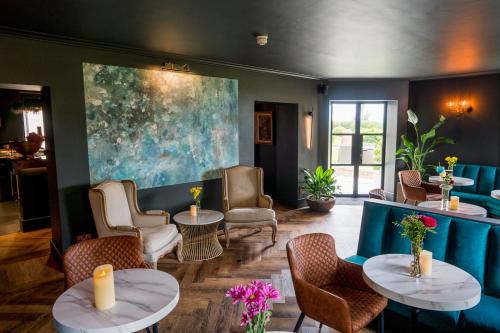 a lobby with tables and chairs and a painting at The Park Hotel in Tenby