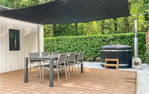 a table and chairs under a black canopy with a trash can at Stunning Home In Putten With Wifi in Putten