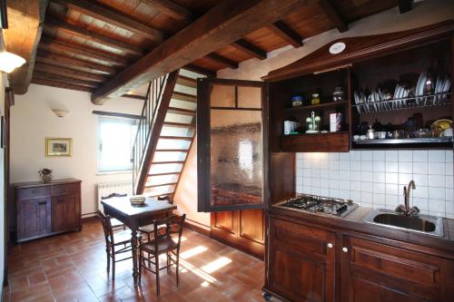 a kitchen with wooden cabinets and a table and chairs at Tenuta San Felice in Giano dellʼUmbria