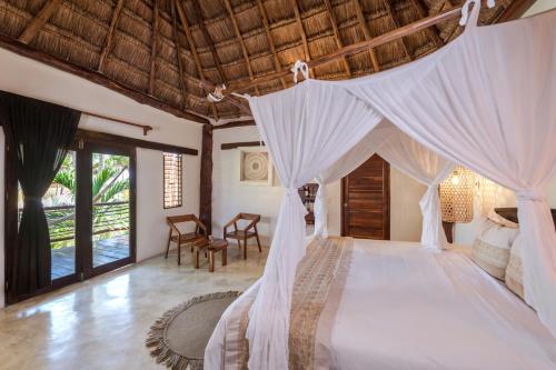 1 dormitorio con 1 cama con dosel en HIP HOTEL By Ana y José - All inclusive, en Tulum