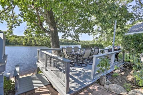 a deck with a table and chairs next to the water at Football Fans Lake Retreat - 5 Mins to Gillette! in Plainville