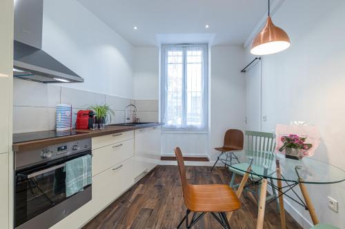 une cuisine avec une table en verre et une salle à manger dans l'établissement LE 323 PROM - 2 chambres - AC - PARKING - tram et supermarché proches - Front de mer, à Nice