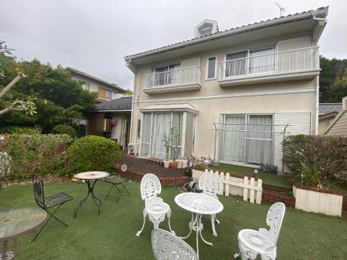 a yard with tables and chairs in front of a house at 澄心小筑 房东住一楼 客人住二楼 每天只接一组客人 雄琴车站免费接送 提供一台免费停车位 in Otsu