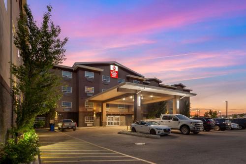 a hotel with cars parked in a parking lot at Best Western PLUS Fort Saskatchewan Inn & Suites in Fort Saskatchewan