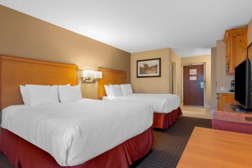um quarto de hotel com duas camas e uma televisão de ecrã plano em Best Western Plus Olympic Inn em Klamath Falls