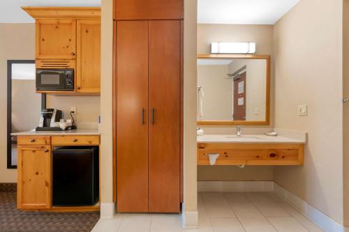 a small kitchen with a sink and a mirror at Best Western Plus Olympic Inn in Klamath Falls