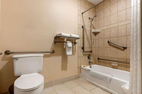 a bathroom with a toilet and a bath tub at Best Western Plus Olympic Inn in Klamath Falls