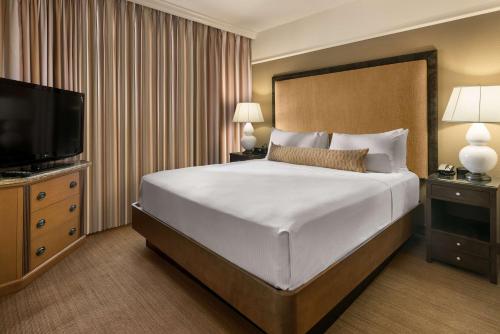 a hotel room with a bed and a flat screen tv at Sonesta Suites Scottsdale Gainey Ranch in Scottsdale