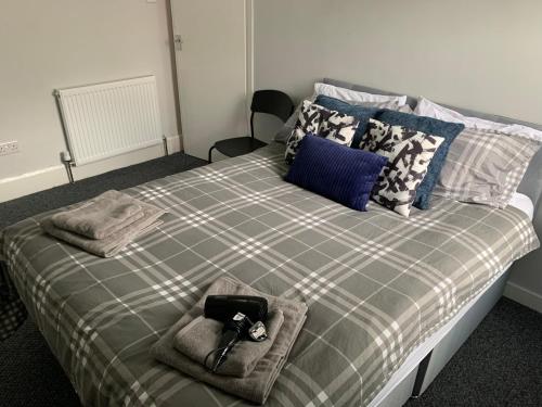 a bedroom with a bed with a plaid blanket at Nelson st ALVA in Largs