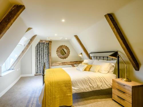 um quarto com uma cama grande e um cobertor amarelo em The Lodge - Uk32622 em Swannington