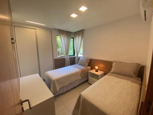 a hotel room with two beds and a window at Iloa Residence Luxo in Barra de São Miguel
