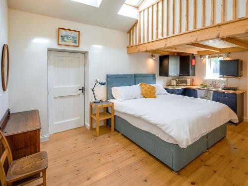 a bedroom with a large bed and a kitchen at Holly Cottage in Kettlewell