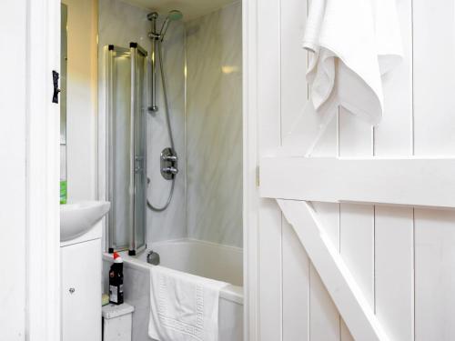 biała łazienka z prysznicem i umywalką w obiekcie Holly Cottage w mieście Kettlewell