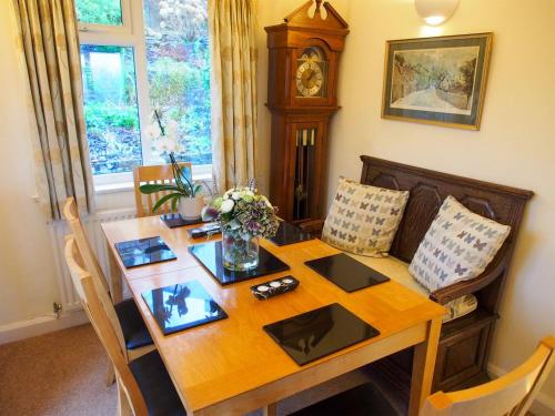 a dining room with a wooden table and a clock at Town View in Burneside