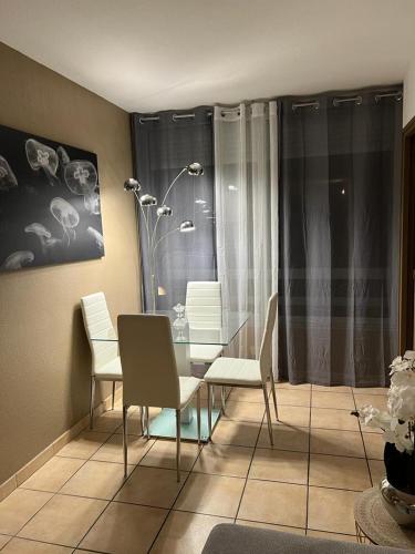 une salle à manger avec des chaises blanches et une table dans l'établissement Appartement 2 pièces Nice, à Nice