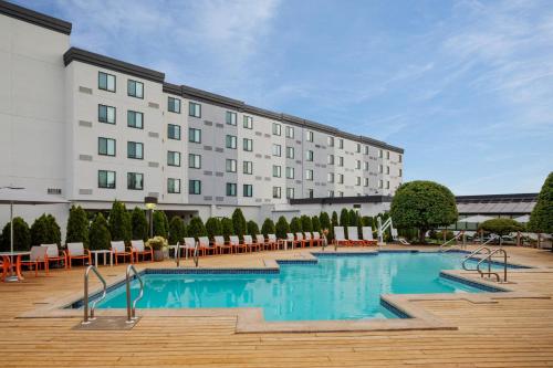 a hotel with a swimming pool in front of a building at Holiday Inn Hasbrouck Heights-Meadowlands, an IHG Hotel in Hasbrouck Heights