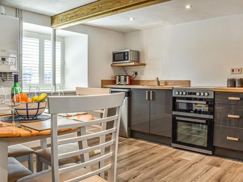 a kitchen with a table and a dining room at Chuckle Cottage in Braunton