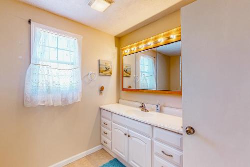 a bathroom with a sink and a mirror at Island Palms in St. George Island