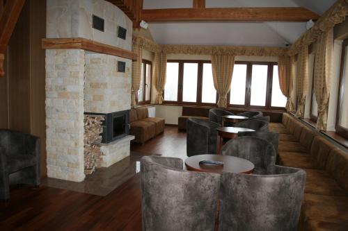 a room with a fireplace and tables and chairs at Hotel Zieleniec in Zieleniec