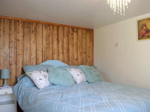 a bedroom with a blue bed with pillows on it at Paramount Cottage in Farden