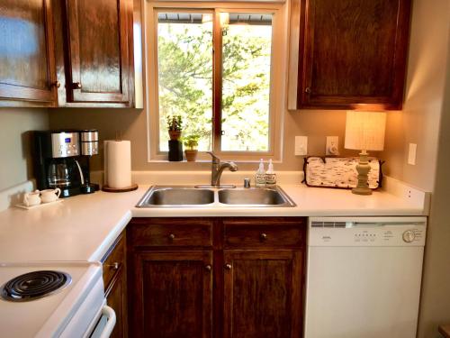 a kitchen with a sink and a stove and a window at Pine Ridge - Memories are made here! in Florissant