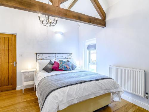 a bedroom with a large bed and a wooden floor at Low Barn in Market Bosworth