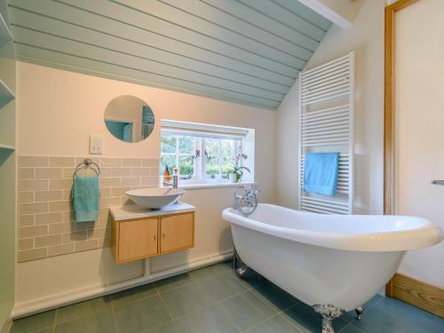 a bathroom with a white tub and a sink at The Hideaway The Den in Sittingbourne