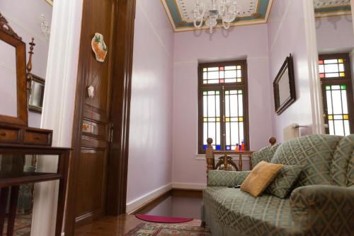 a living room with a couch and a chandelier at Vogiatzopoulou Guesthouse in Agios Georgios Nilias