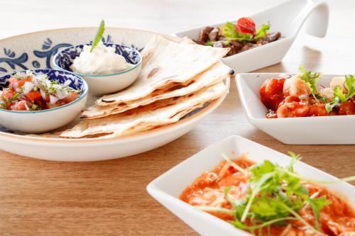 a table topped with bowls of different types of food at Terra Inn Hotel Boutique in Guaduas