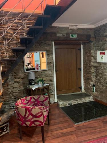 a room with a staircase with a door and a chair at Casa do Soto in Milhão