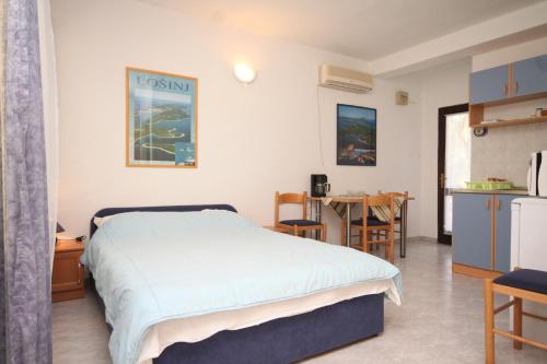 a bedroom with a bed and a table and a kitchen at Apartments with a parking space Artatore, Losinj - 8007 in Cunski