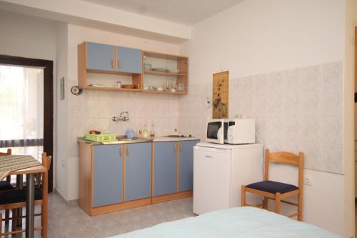 a small kitchen with a refrigerator and a microwave at Apartments with a parking space Artatore, Losinj - 8007 in Cunski