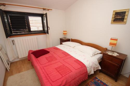 ein Schlafzimmer mit einem Bett mit einer roten Decke in der Unterkunft Apartments with parking space Rovinj - 7656 in Rovinj