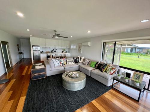 a living room with a couch and a table at Perfect weekend getaway plus golf at your doorstep in Salamander Bay