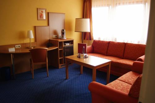 a hotel room with a couch and a table at Hotel Altenberg in Baden-Baden