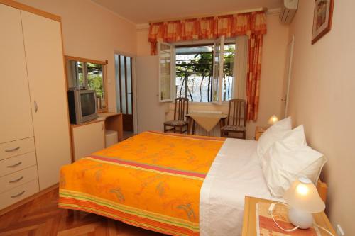a bedroom with a bed and a kitchen and a table at Rooms by the sea Medveja, Opatija - 7775 in Lovran