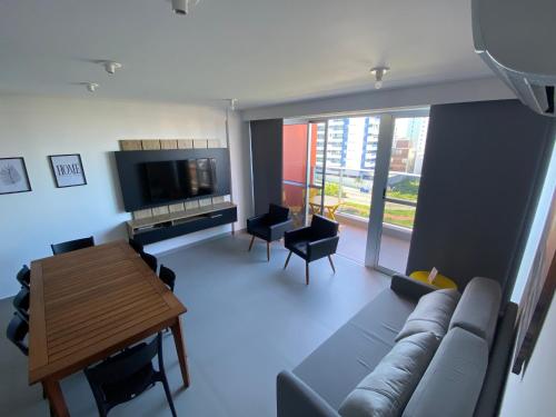 a living room with a couch and a table and a television at Villi 503C in João Pessoa