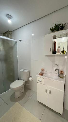 Baño blanco con aseo y lavamanos en Apto Alamanda - Aconchegante, Confortável e bem localizado!, en Piratuba