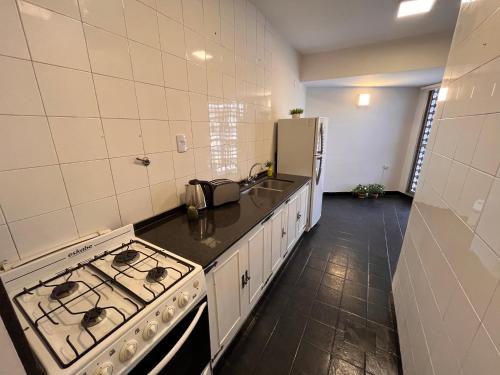 a kitchen with a stove and a refrigerator at Departamento Urquiza in San Miguel de Tucumán