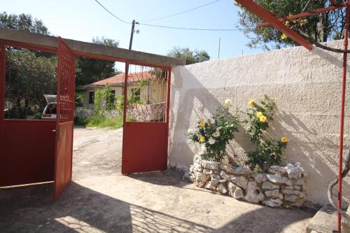 a red door with a bush of flowers on a wall at Apartments by the sea Basina, Hvar - 8749 in Vrbanj