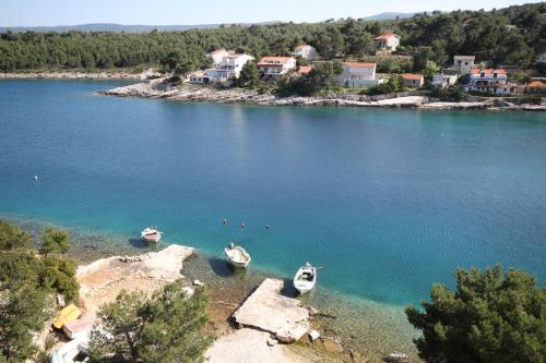 three boats sitting on the shore of a lake at Apartments by the sea Basina, Hvar - 8749 in Vrbanj
