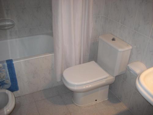 a bathroom with a toilet and a sink and a tub at Holiday homes Bonamar in Colònia de Sant Jordi