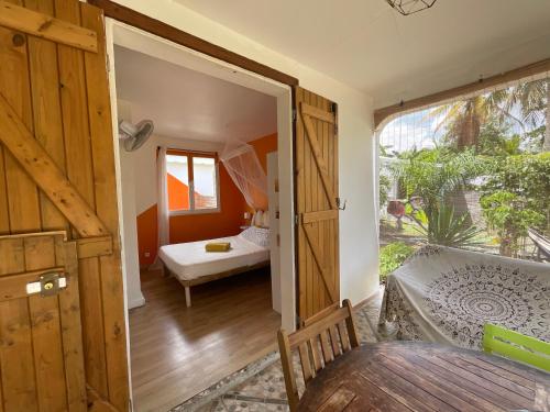 a room with a door open to a bedroom with a bed at BUNGALOWS LES VAGUES ABONDES in Sainte-Anne