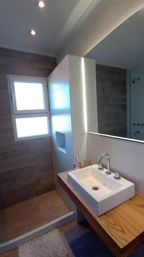 a bathroom with a sink and a mirror and a shower at Los Colibries II in San Pedro