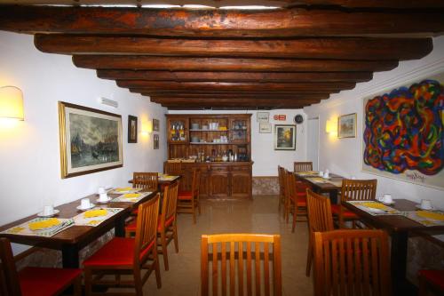 威尼斯的住宿－達拉莫拉酒店，用餐室配有木桌和椅子