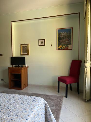 1 dormitorio con 1 cama y 1 silla roja en Il viandante, en Olivarella