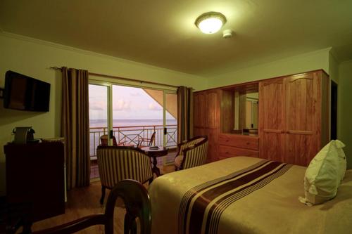 a hotel room with a bed and a view of the ocean at Treasure Cove Hotel & Restaurant in Bel Ombre