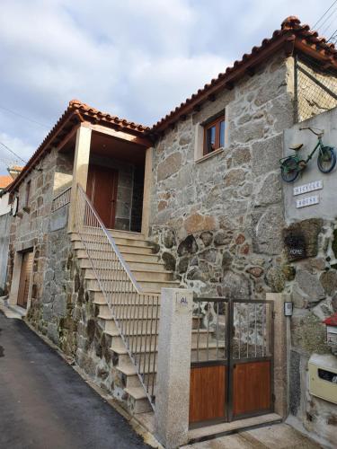 uma casa de pedra com escadas em frente em Bicycle House em Felgueiras