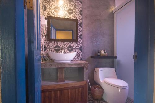 uma casa de banho com um lavatório, um WC e um espelho. em Maison Zen Aphay em Luang Prabang